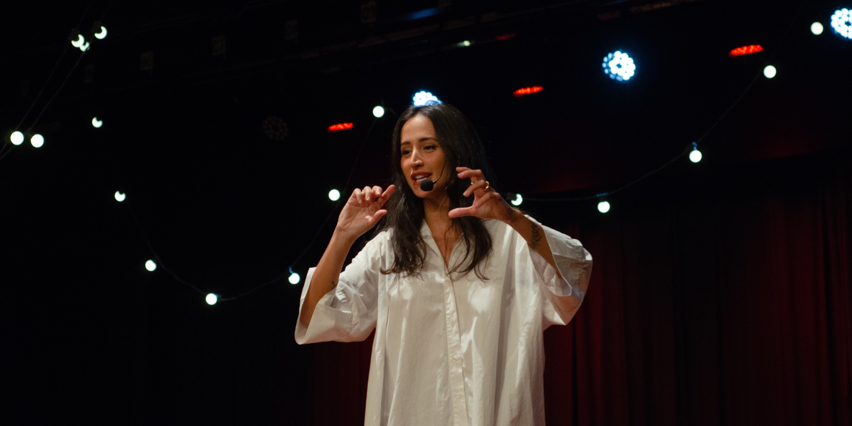 Woman speaking on stage with dark background